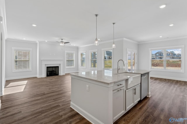 kitchen featuring a center island with sink, light stone countertops, dishwasher, white cabinets, and pendant lighting