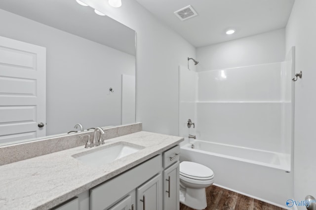 full bathroom featuring hardwood / wood-style floors, toilet, shower / washtub combination, and vanity