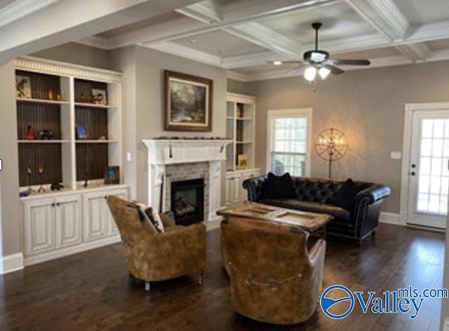 living room featuring coffered ceiling, ceiling fan, dark wood-type flooring, a fireplace, and beam ceiling