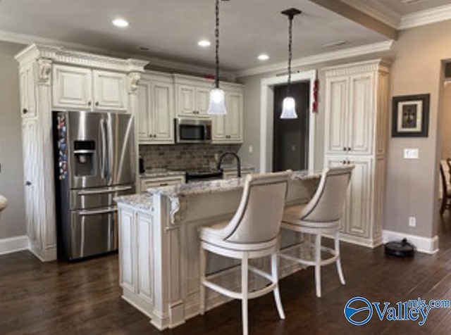 kitchen featuring dark wood-style flooring, stainless steel appliances, backsplash, ornamental molding, and a kitchen bar