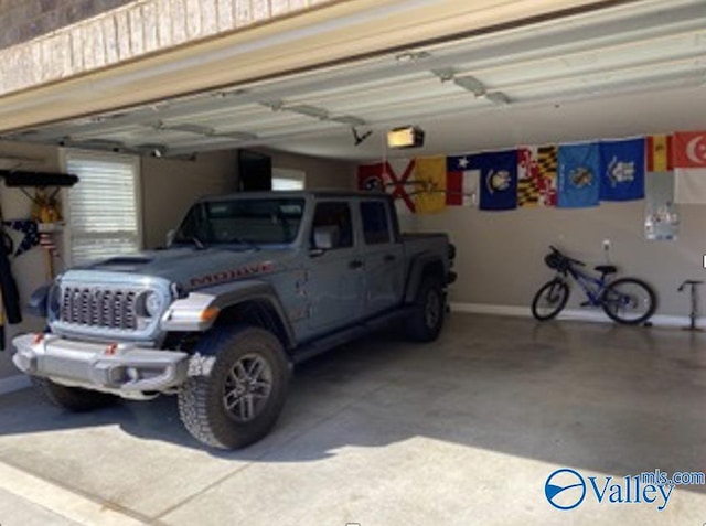 garage with baseboards and a garage door opener