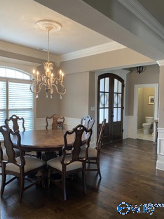 dining room with arched walkways, a chandelier, wood finished floors, french doors, and crown molding