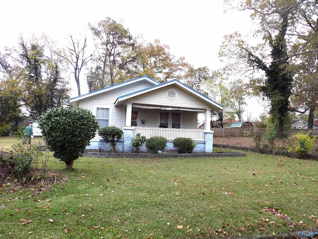 view of side of property featuring a porch and a lawn