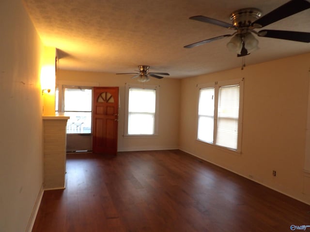 unfurnished room with ceiling fan, a fireplace, and dark hardwood / wood-style floors