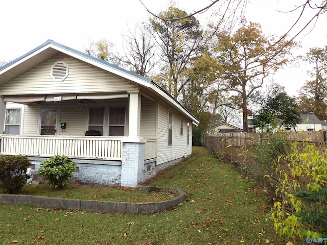 view of home's exterior with a porch and a yard