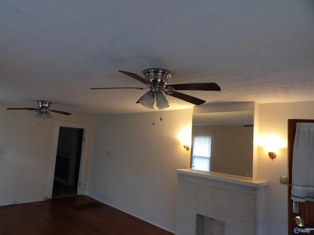 empty room featuring a fireplace, dark hardwood / wood-style floors, and ceiling fan