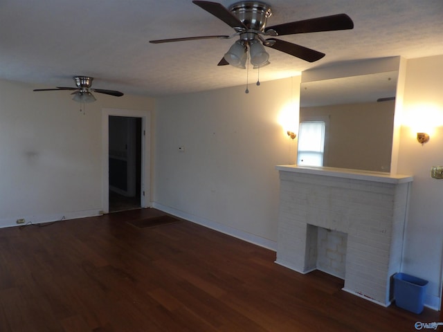 unfurnished living room featuring ceiling fan, a fireplace, and dark hardwood / wood-style floors