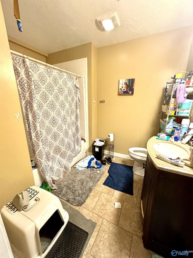 bathroom with a textured ceiling, toilet, vanity, and tile patterned flooring