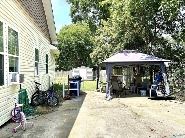 view of patio / terrace with cooling unit, a gazebo, and a storage shed