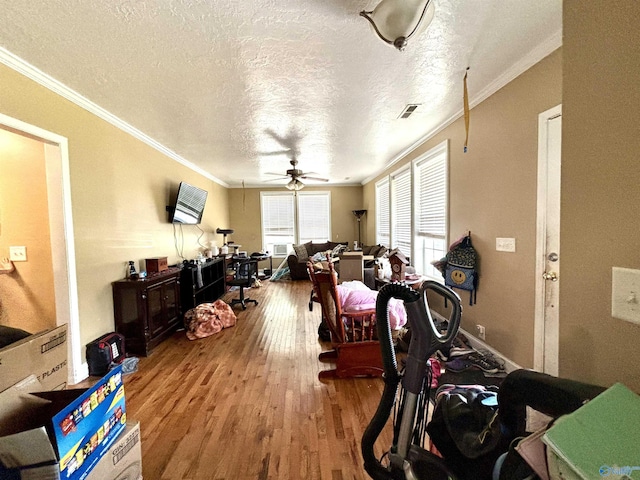 interior space with crown molding, ceiling fan, a textured ceiling, and light hardwood / wood-style floors