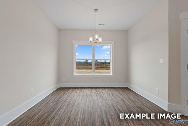 empty room featuring dark hardwood / wood-style floors and an inviting chandelier