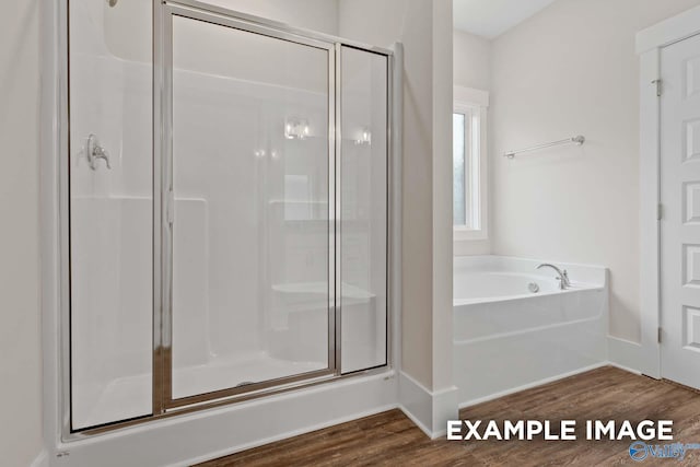 bathroom featuring independent shower and bath and hardwood / wood-style floors