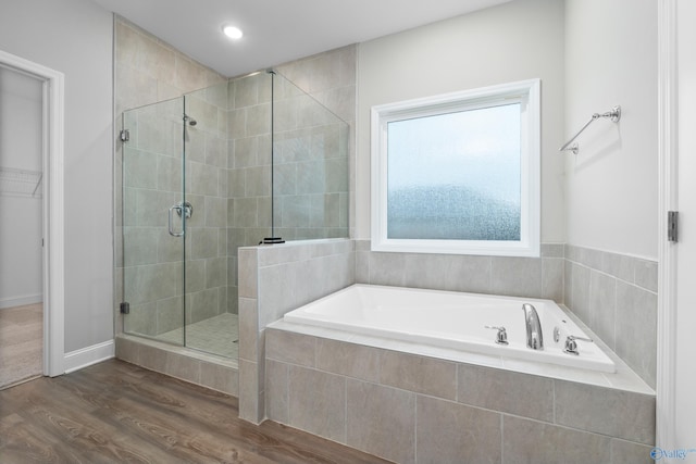 bathroom featuring independent shower and bath and hardwood / wood-style floors