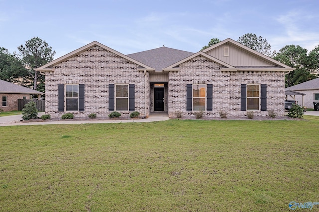 ranch-style house featuring brick siding, a shingled roof, and a front lawn