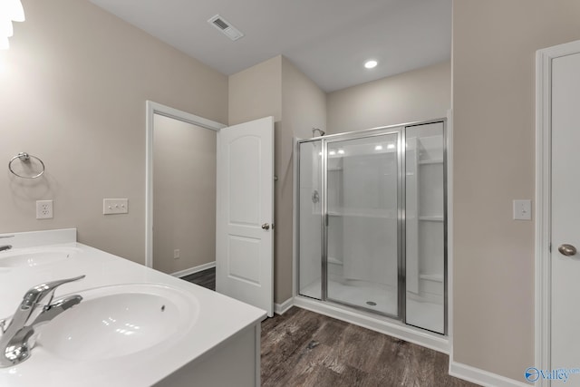 full bath featuring a shower stall, wood finished floors, visible vents, and a sink