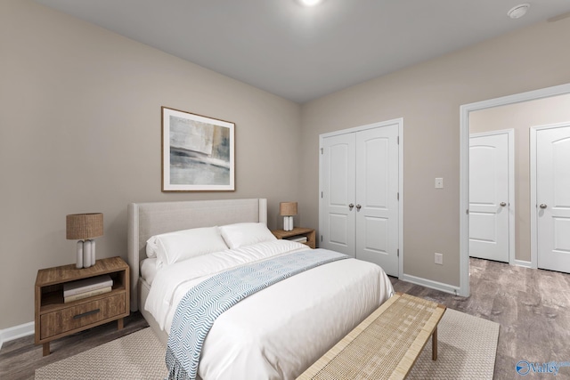 bedroom featuring a closet, baseboards, and wood finished floors