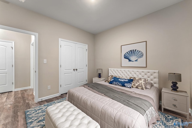 bedroom featuring a closet, baseboards, and wood finished floors