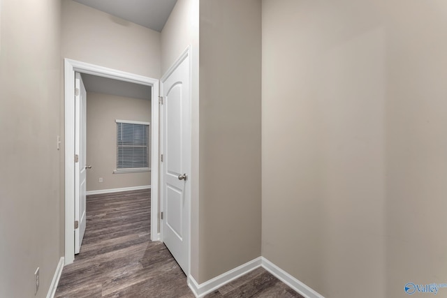 hallway featuring dark wood-style floors and baseboards