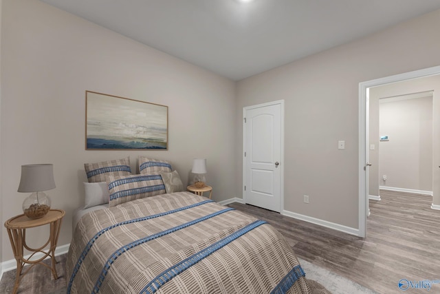 bedroom with baseboards and wood finished floors