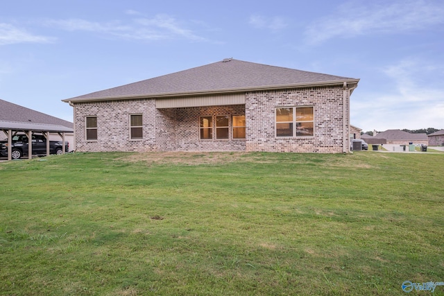 back of property featuring cooling unit, a lawn, brick siding, and roof with shingles