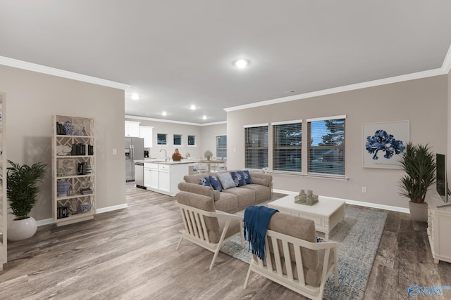 living room featuring crown molding, light wood-type flooring, and baseboards