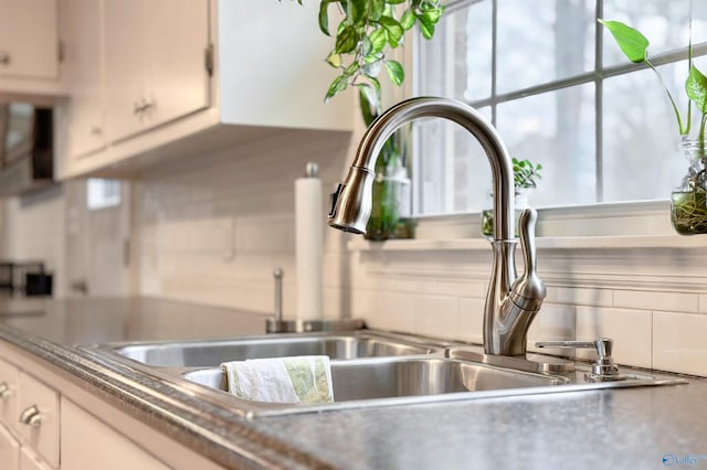 kitchen with backsplash, sink, and white cabinets