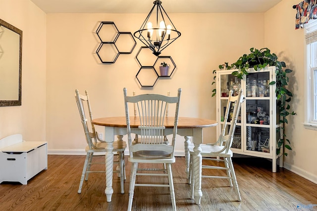 dining area with hardwood / wood-style flooring and a chandelier