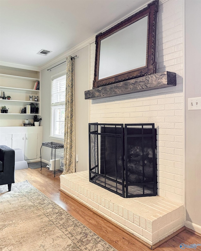 living room with hardwood / wood-style flooring, a fireplace, and ornamental molding