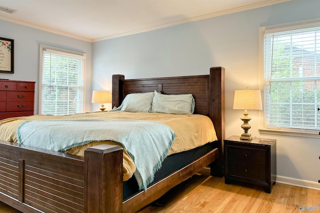 bedroom with ornamental molding and light wood-type flooring