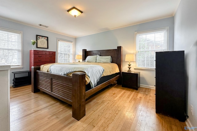 bedroom featuring crown molding and light hardwood / wood-style flooring