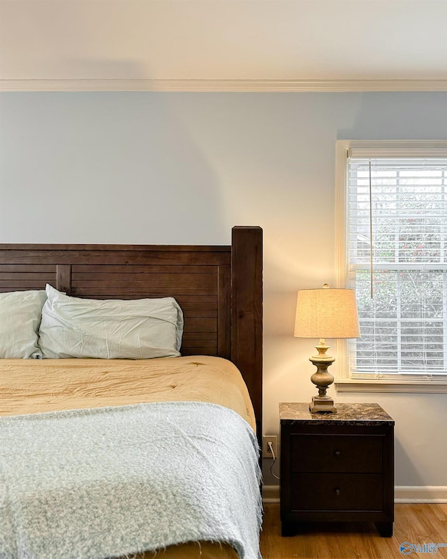 bedroom with crown molding and wood-type flooring