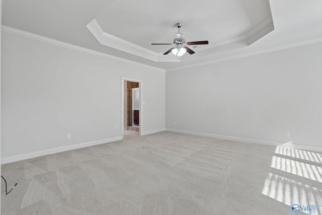 carpeted empty room featuring a tray ceiling, ceiling fan, and crown molding