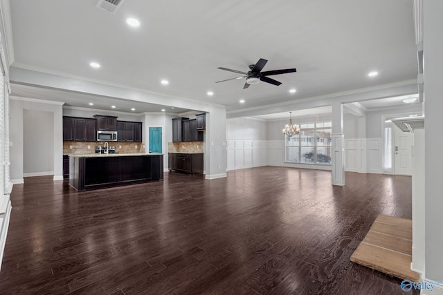 unfurnished living room with dark hardwood / wood-style floors, crown molding, and ceiling fan with notable chandelier