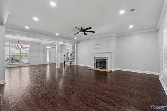 unfurnished living room with dark hardwood / wood-style flooring, a fireplace, ceiling fan with notable chandelier, and ornamental molding