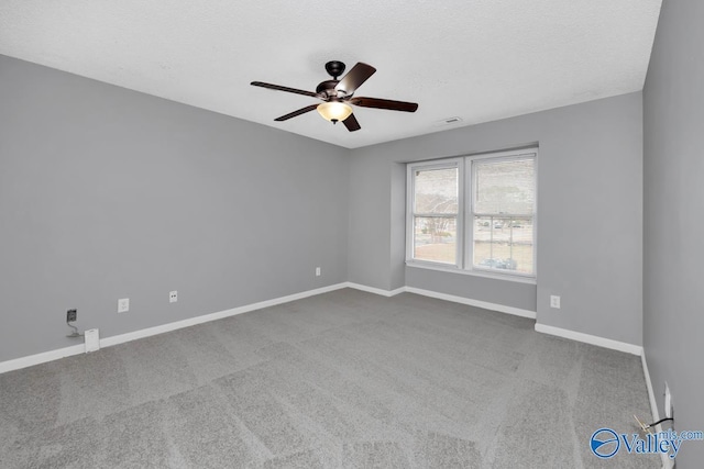 carpeted empty room with ceiling fan and a textured ceiling