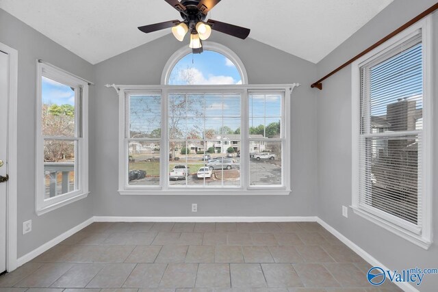 unfurnished dining area featuring plenty of natural light, light tile patterned floors, and vaulted ceiling