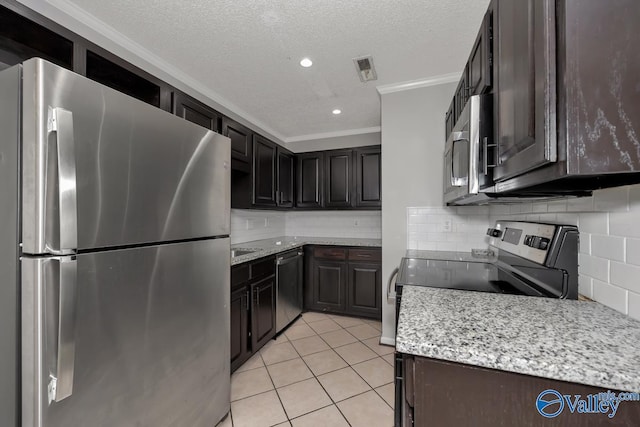 kitchen with crown molding, a textured ceiling, decorative backsplash, light tile patterned floors, and appliances with stainless steel finishes