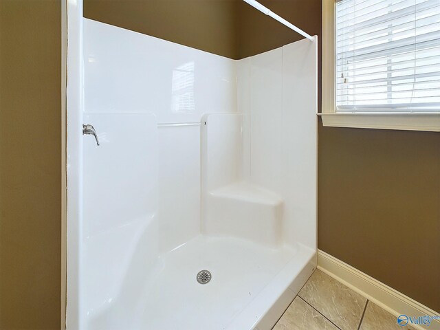 bathroom with walk in shower and tile patterned flooring