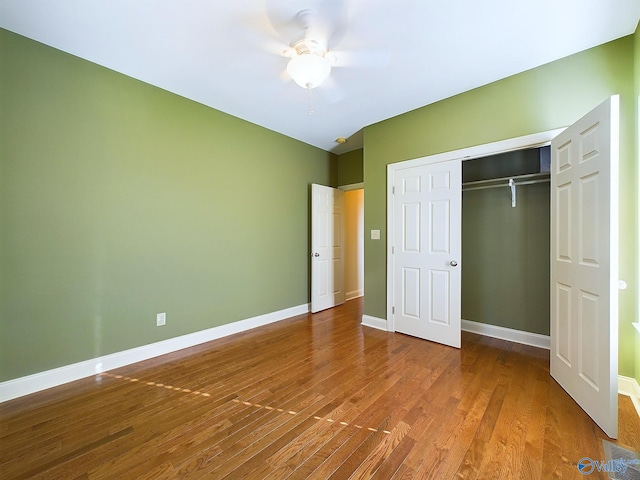 unfurnished bedroom featuring ceiling fan, a closet, and hardwood / wood-style flooring