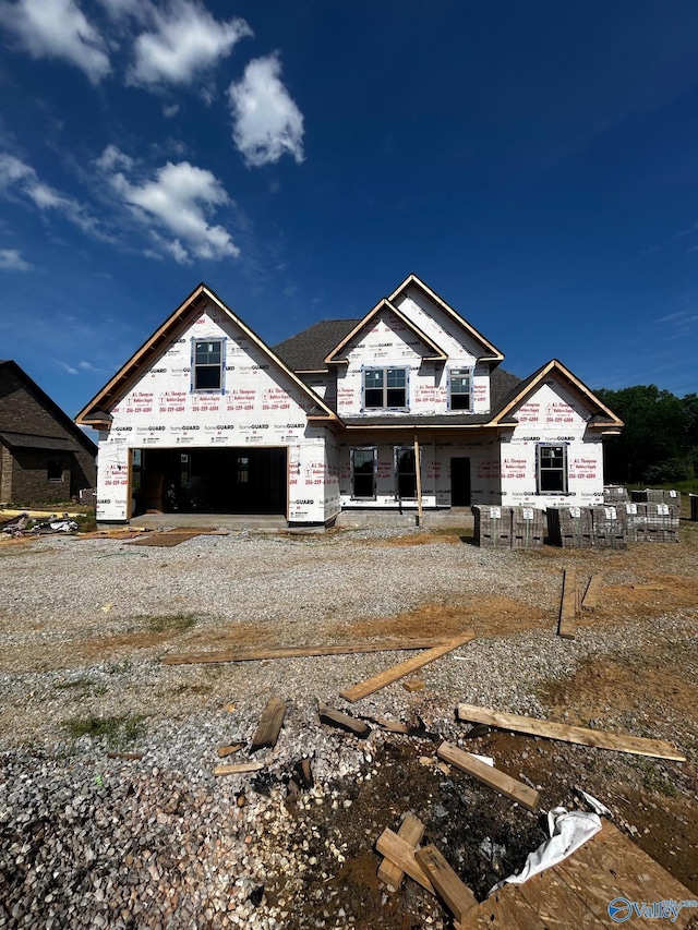 property under construction featuring a garage and gravel driveway