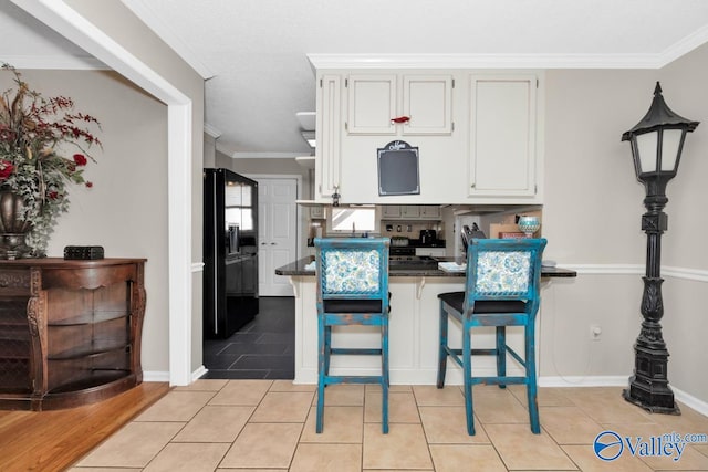 kitchen with kitchen peninsula, black refrigerator with ice dispenser, crown molding, and white cabinetry