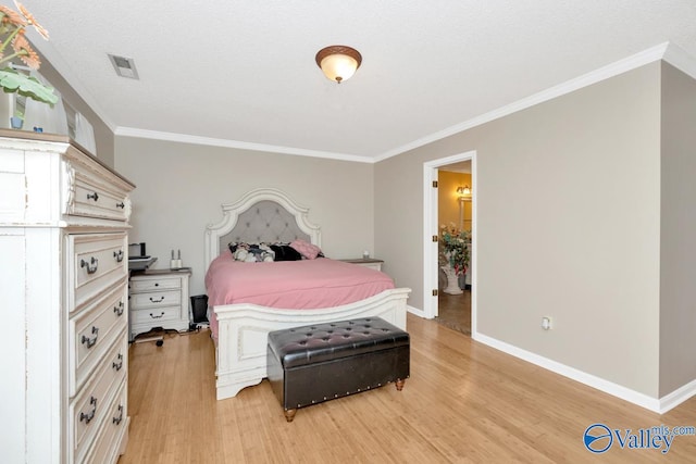 bedroom with crown molding, ensuite bath, and light hardwood / wood-style flooring