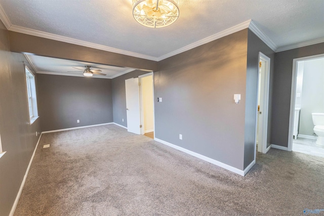 empty room with carpet floors, ornamental molding, a textured ceiling, and baseboards