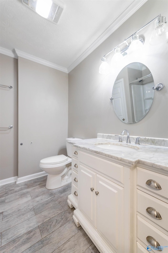 bathroom featuring toilet, visible vents, ornamental molding, and vanity