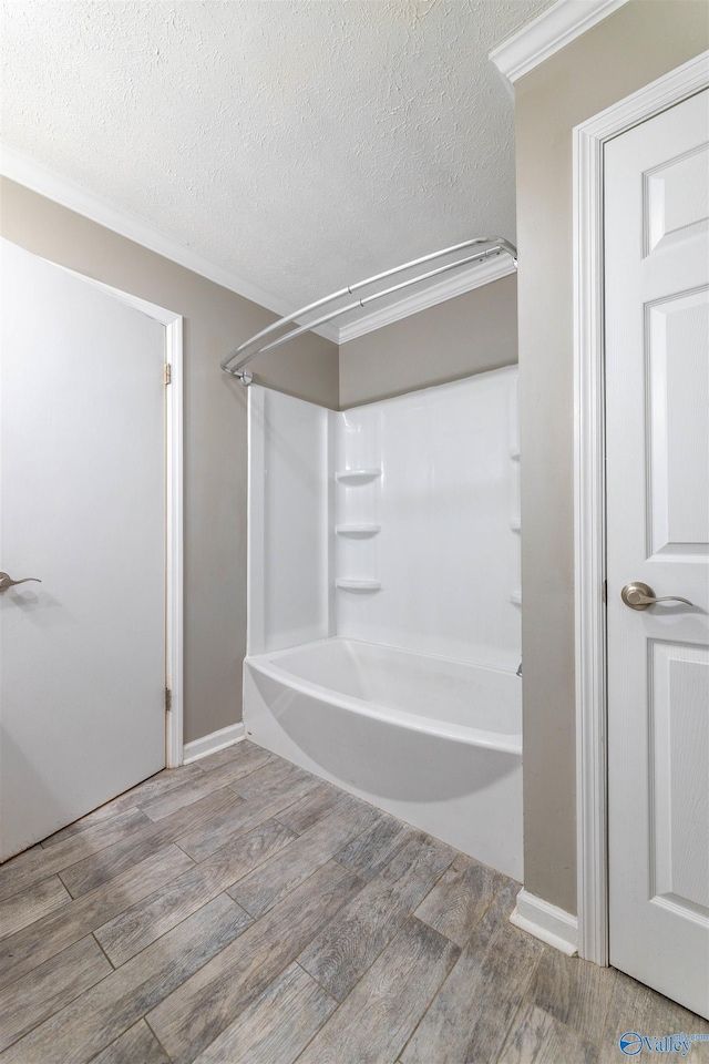 full bathroom featuring crown molding, a textured ceiling, shower / bathtub combination, and wood finished floors