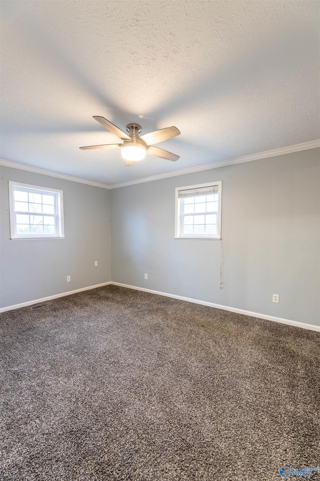 carpeted spare room with baseboards, ornamental molding, and a wealth of natural light