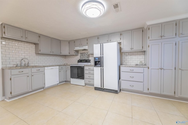 kitchen with gray cabinets, visible vents, a sink, white appliances, and under cabinet range hood