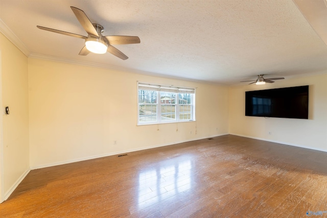 empty room with crown molding, ceiling fan, a textured ceiling, wood finished floors, and baseboards