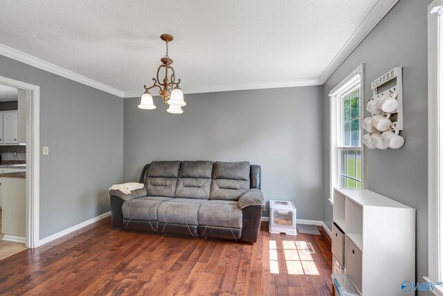 living room with dark hardwood / wood-style floors, a notable chandelier, ornamental molding, and a textured ceiling