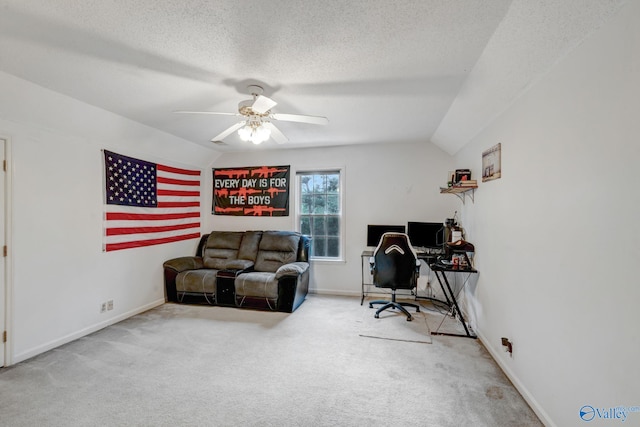 carpeted home office with a textured ceiling, ceiling fan, and vaulted ceiling